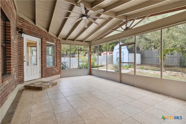 unfurnished sunroom featuring ceiling fan, vaulted ceiling with beams, and wood ceiling