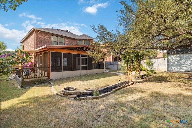 back of house with a lawn and a sunroom