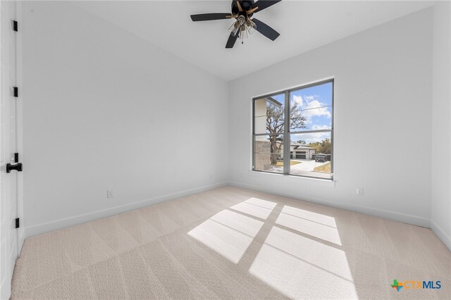 carpeted spare room with ceiling fan