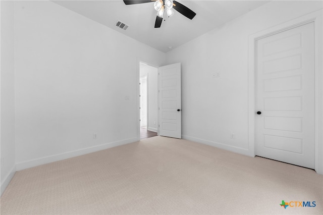 spare room with light colored carpet and ceiling fan