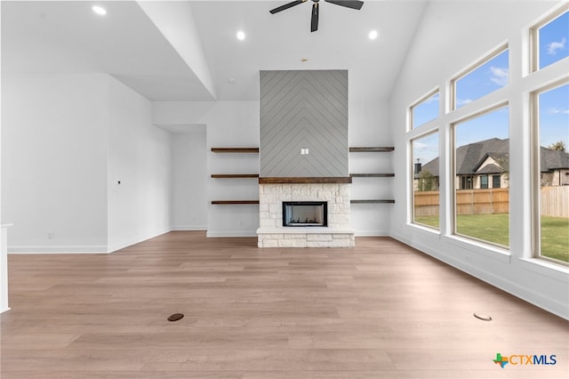 unfurnished living room featuring a fireplace, light hardwood / wood-style floors, and a healthy amount of sunlight