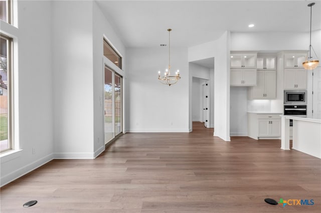 interior space featuring a chandelier, a healthy amount of sunlight, and light hardwood / wood-style flooring