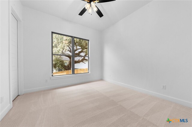 carpeted empty room featuring ceiling fan and lofted ceiling