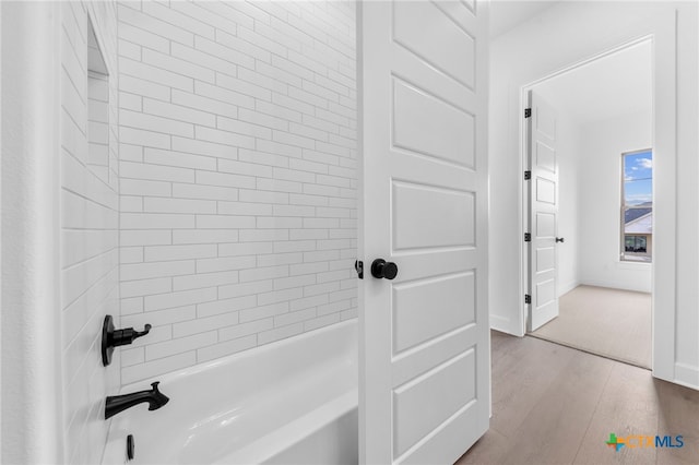 bathroom featuring tiled shower / bath combo and hardwood / wood-style flooring