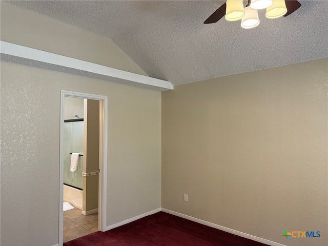 unfurnished bedroom featuring ensuite bathroom, ceiling fan, a textured ceiling, and vaulted ceiling