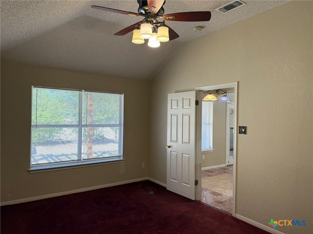 carpeted spare room with lofted ceiling, a textured ceiling, and ceiling fan