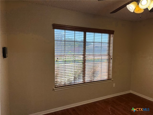 unfurnished room featuring ceiling fan, a textured ceiling, and dark hardwood / wood-style floors