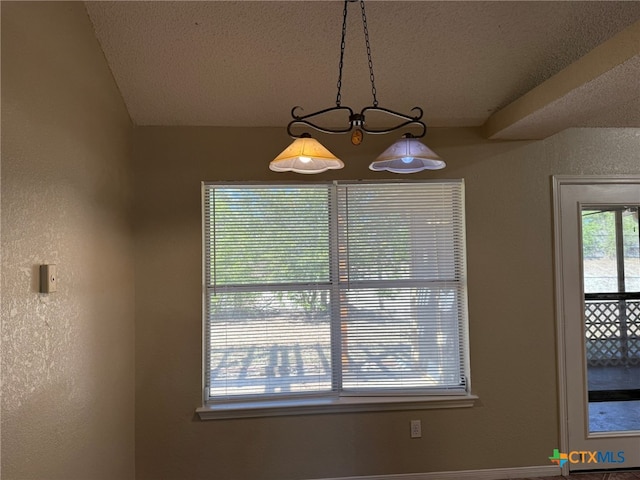 interior space featuring a textured ceiling and an inviting chandelier