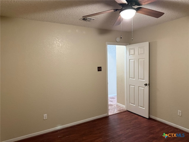 spare room with a textured ceiling, dark wood-type flooring, and ceiling fan