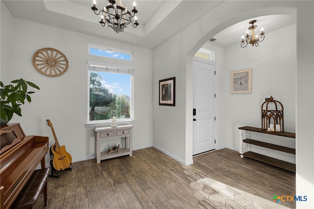 1882 Rush Crk, Canyon Lake, TX 78133 - entrance foyer featuring a chandelier, arched walkways, wood finished floors, a tray ceiling, and baseboards