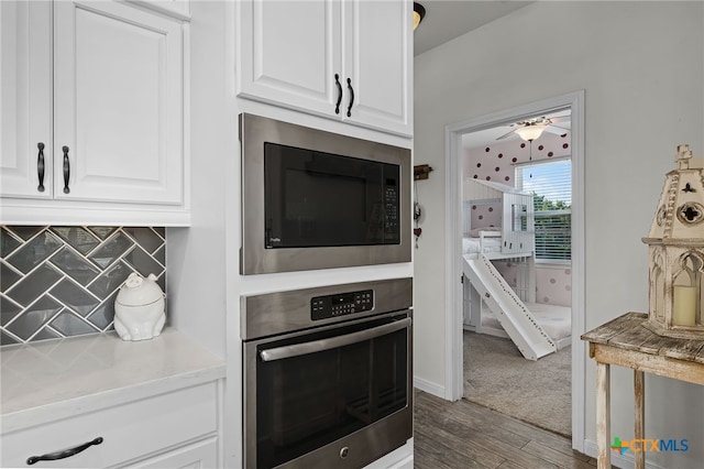 1882 Rush Crk, Canyon Lake, TX 78133 - kitchen featuring appliances with stainless steel finishes, wood finished floors, white cabinets, and tasteful backsplash