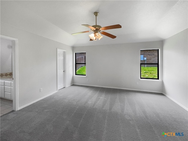 spare room with a wealth of natural light, carpet floors, and ceiling fan