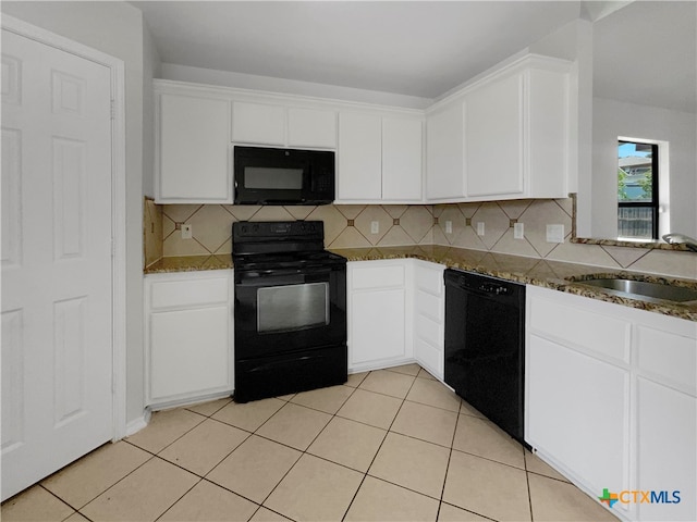 kitchen featuring black appliances, white cabinetry, dark stone counters, and sink