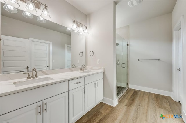 bathroom featuring hardwood / wood-style floors, vanity, and a shower with door