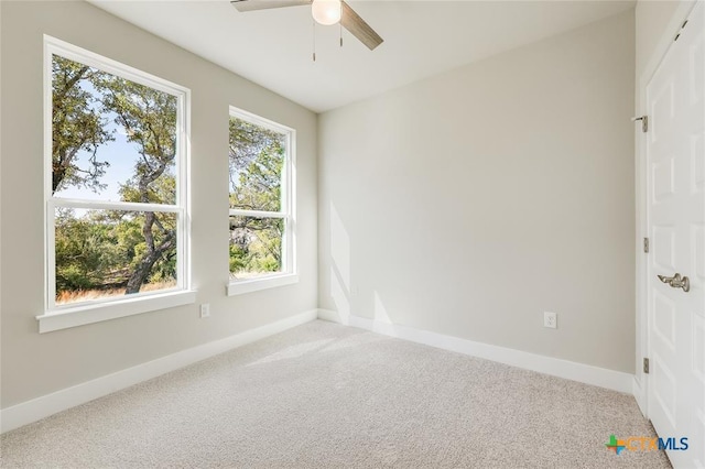 carpeted spare room featuring ceiling fan