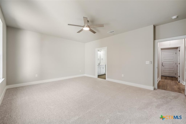 unfurnished bedroom featuring carpet flooring, ensuite bath, and ceiling fan