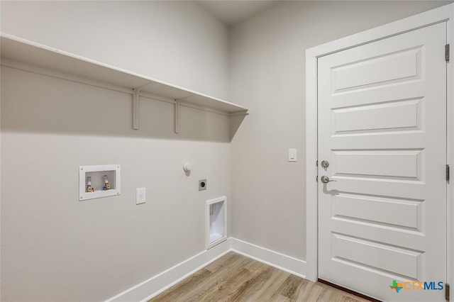 clothes washing area with hookup for an electric dryer, washer hookup, light hardwood / wood-style floors, and gas dryer hookup