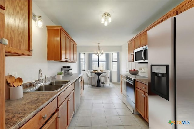 2703 Casey Dr, Killeen, TX 76543 - kitchen with appliances with stainless steel finishes, a sink, a chandelier, light tile patterned floors, and pendant lighting