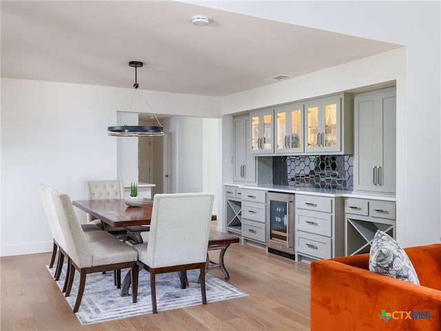 3415 Chisholm Trl, Salado, TX 76571 - interior space featuring light wood-style floors, decorative backsplash, a bar, and beverage cooler