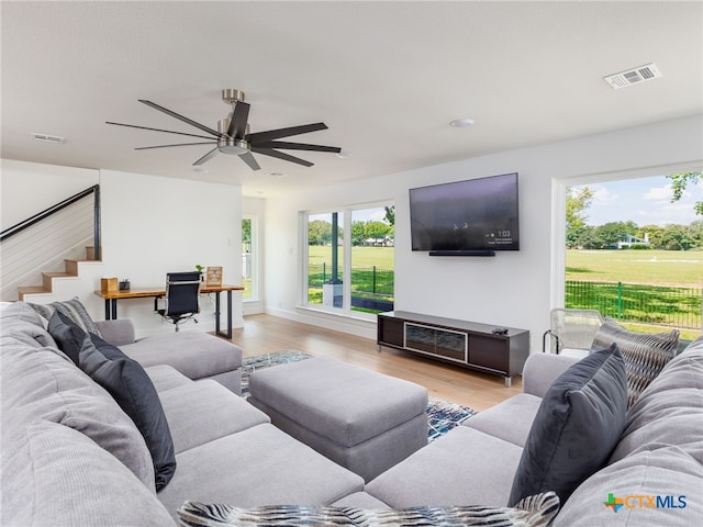 3415 Chisholm Trl, Salado, TX 76571 - living room featuring a ceiling fan, stairs, light wood-style floors, and visible vents