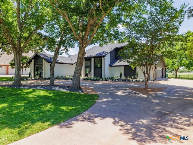 3415 Chisholm Trl, Salado, TX 76571 - mid-century inspired home featuring driveway, stucco siding, a front yard, and an attached garage