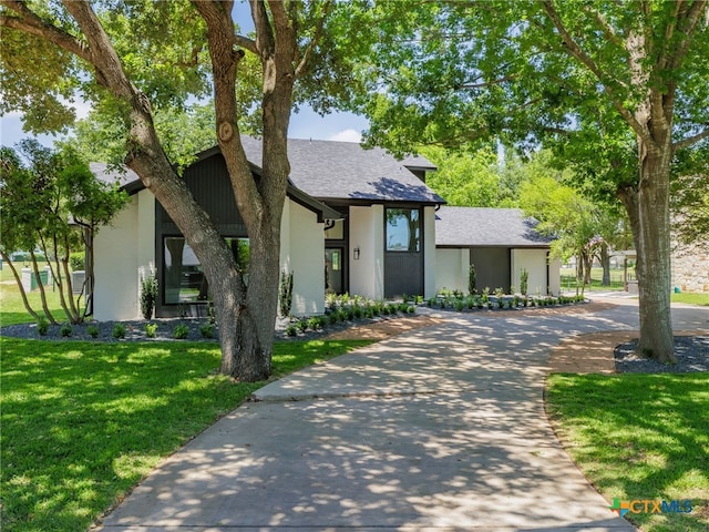 3415 Chisholm Trl, Salado, TX 76571 - view of front of house with concrete driveway, a front yard, stucco siding, and a shingled roof