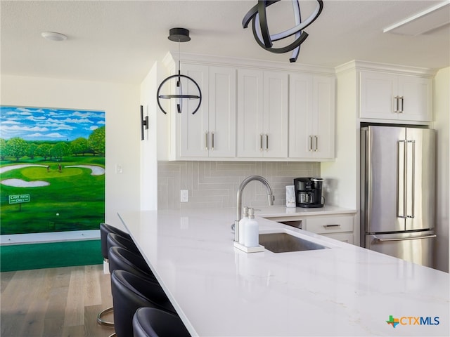 3415 Chisholm Trl, Salado, TX 76571 - kitchen with high quality fridge, a sink, decorative backsplash, wood finished floors, and white cabinets