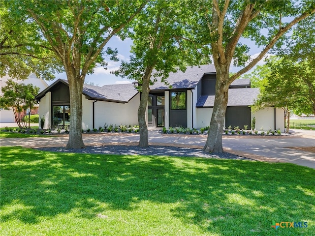 3415 Chisholm Trl, Salado, TX 76571 - mid-century modern home featuring stucco siding, roof with shingles, and a front yard