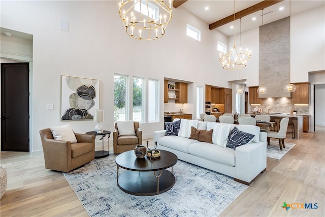 living area with recessed lighting, baseboards, light wood-style floors, beam ceiling, and an inviting chandelier