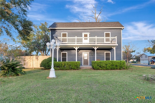 view of front facade with a balcony and a front yard