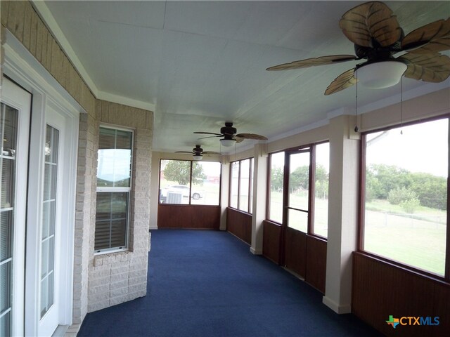 unfurnished sunroom featuring ceiling fan