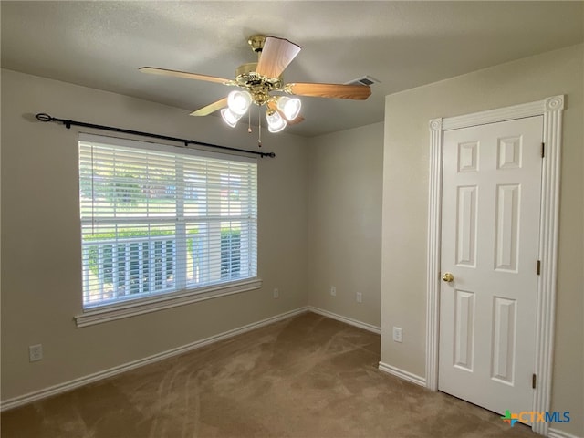 carpeted empty room featuring ceiling fan