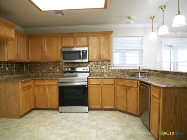 kitchen featuring pendant lighting, stainless steel appliances, sink, and plenty of natural light