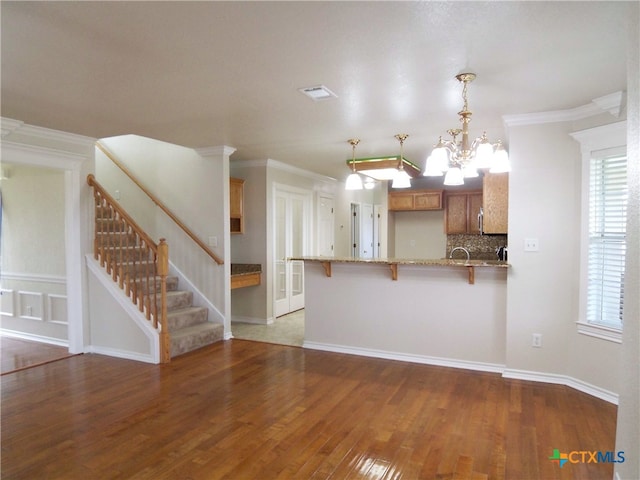 kitchen with pendant lighting, kitchen peninsula, a wealth of natural light, and dark wood-type flooring