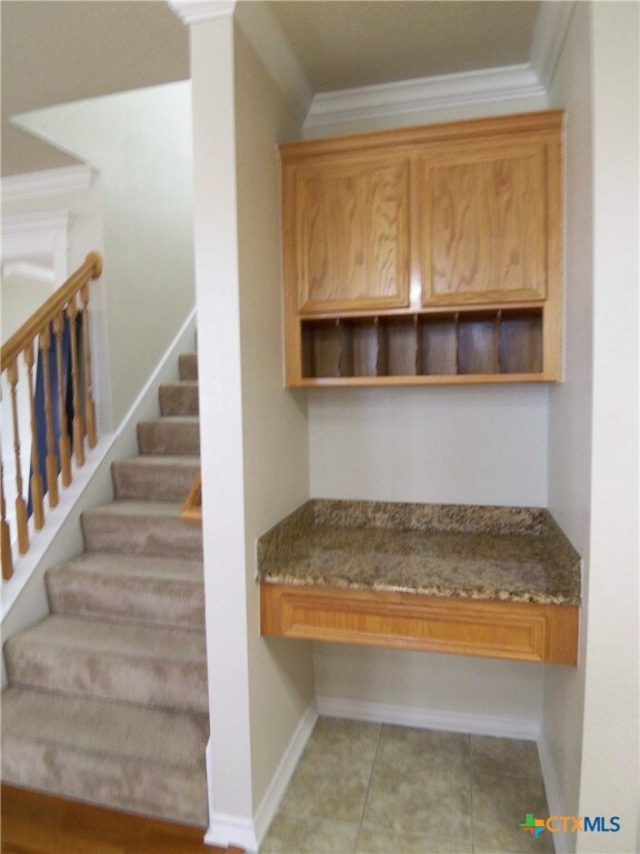 mudroom featuring light tile patterned flooring and ornamental molding