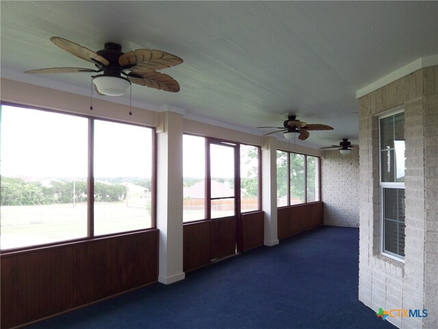 unfurnished sunroom with ceiling fan