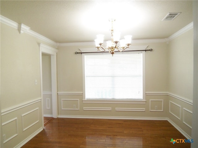 empty room with dark hardwood / wood-style flooring, a chandelier, and crown molding