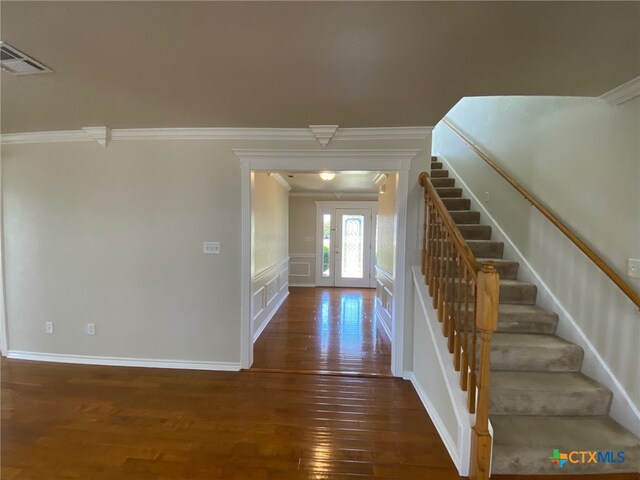 foyer entrance featuring french doors, dark hardwood / wood-style floors, and crown molding