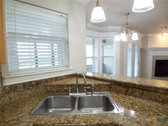 kitchen with hanging light fixtures, sink, a notable chandelier, and crown molding