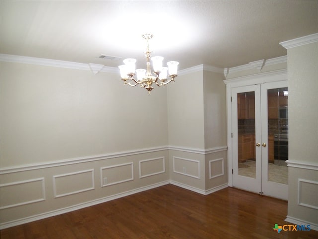 spare room with dark wood-type flooring, a chandelier, french doors, and ornamental molding