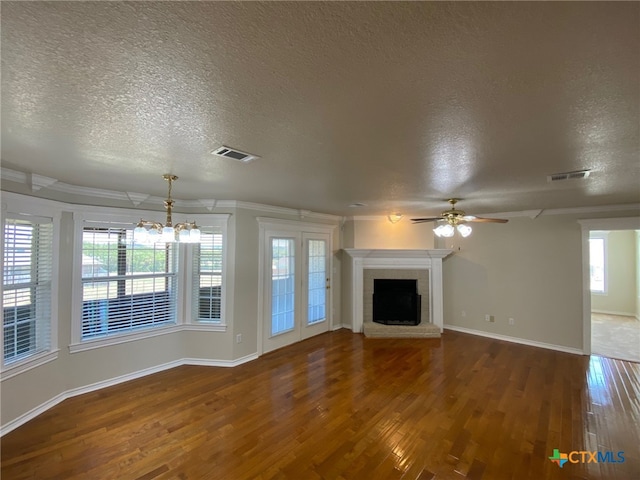 unfurnished living room featuring plenty of natural light, a textured ceiling, and dark hardwood / wood-style floors