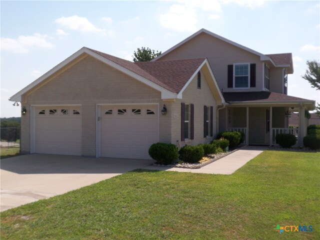 view of front of property with a front yard, a porch, and a garage