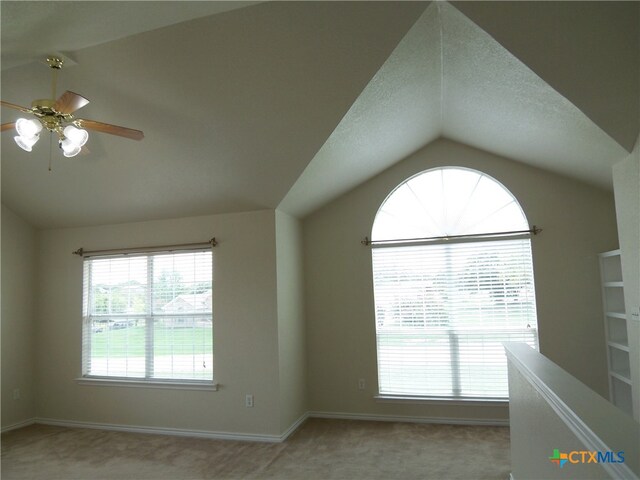 carpeted spare room with lofted ceiling and ceiling fan