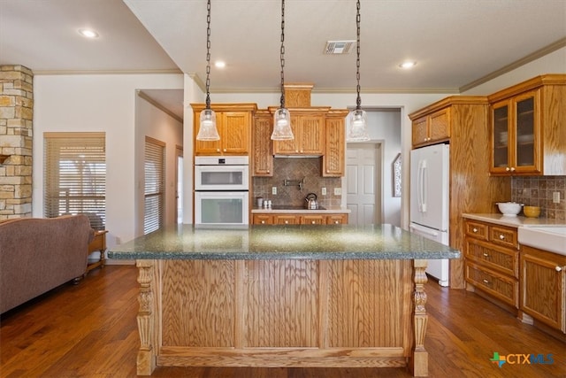 kitchen with dark wood-type flooring, tasteful backsplash, pendant lighting, and white appliances