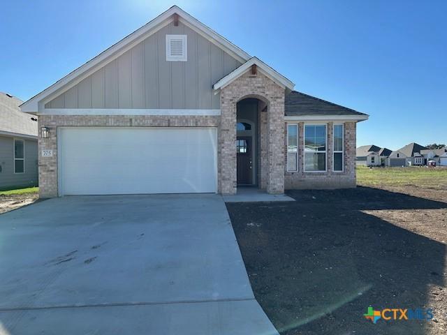 view of front of house with a garage, concrete driveway, and board and batten siding