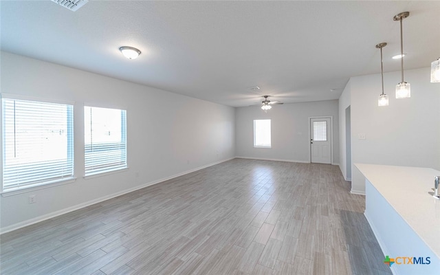 unfurnished living room with hardwood / wood-style flooring and ceiling fan