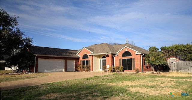 ranch-style home featuring a garage, brick siding, a front yard, and fence