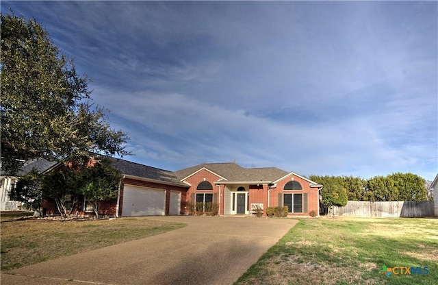 single story home with brick siding, concrete driveway, a front yard, fence, and a garage