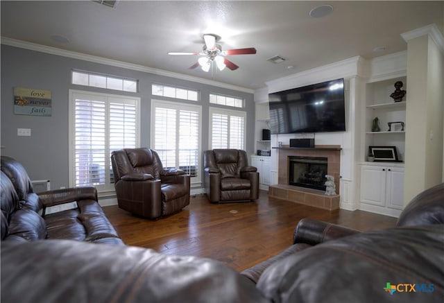 living room featuring crown molding, visible vents, ceiling fan, wood finished floors, and a tile fireplace