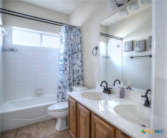 bathroom featuring double vanity, shower / bath combo, a sink, and toilet